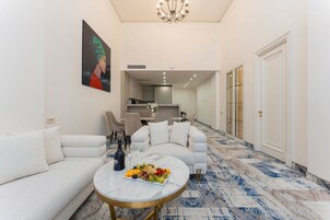 Een moderne woonkamer met een bank, een salontafel met fruit en een schilderij aan de muur.