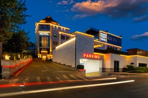 Een hotel met een opvallend 'HOTEL' bord, een 'PARKING' bord en een 'VENICE' bord.