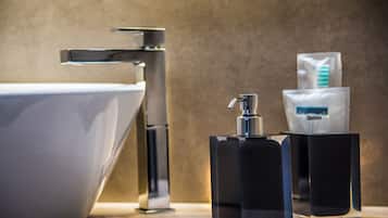 A modern bathroom with a sleek faucet, a white sink, and a soap dispenser.
