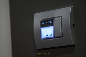 Un pannello di controllo con icone illuminate per le impostazioni della stanza.