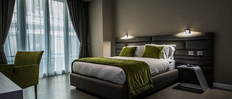 Una habitación de hotel moderna con una cama grande, un escritorio y una silla.
