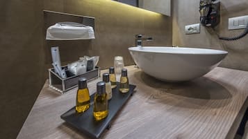 Un baño moderno con un lavamanos grande tipo recipiente, un perchero y un secador de pelo montado en la pared.