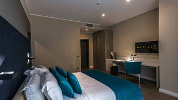 Een moderne hotelkamer met een bed, een bureau en een stoel.