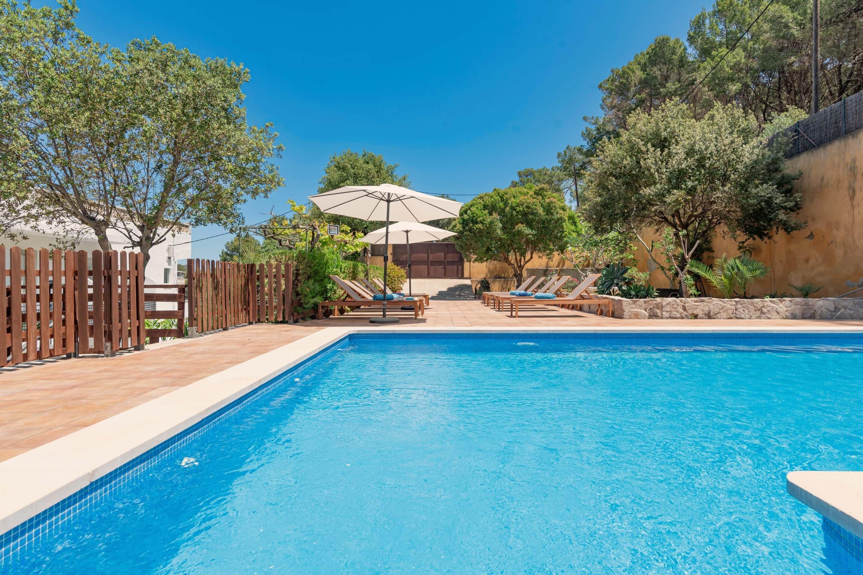 Una piscina al aire libre, sillones reclinables de piscina