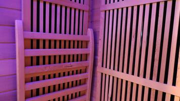 A wooden room with a slatted partition and a wooden floor.