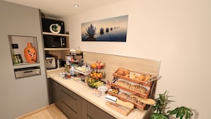 A modern kitchen with a microwave, coffee maker, and various food items on the counter. - Le Lotus Blanc (Albertville)