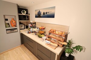 Une cuisine moderne équipée d’un four à micro-ondes, d’une machine à café et de divers produits alimentaires disposés sur le plan de travail.