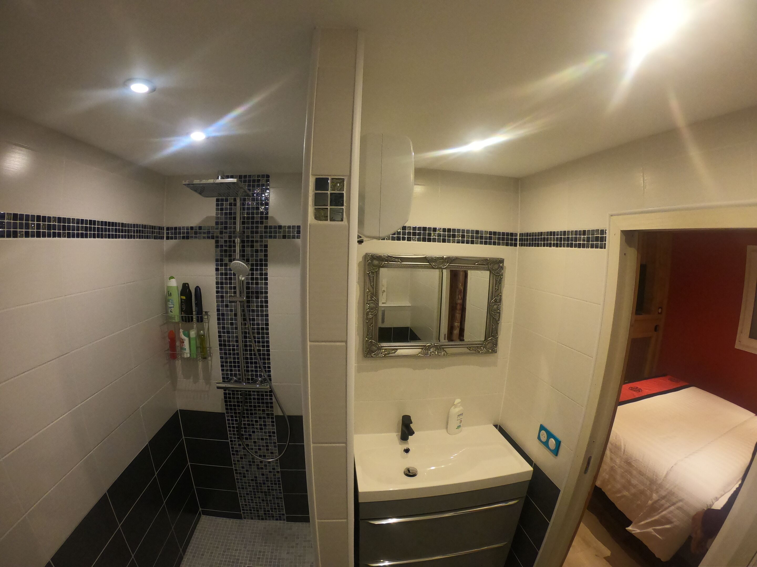 A bathroom with a shower, sink, and mirror.