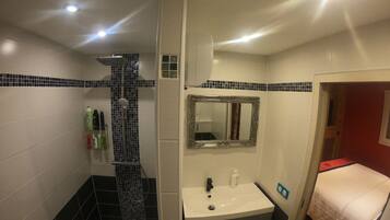 A bathroom with a shower, sink, and mirror.