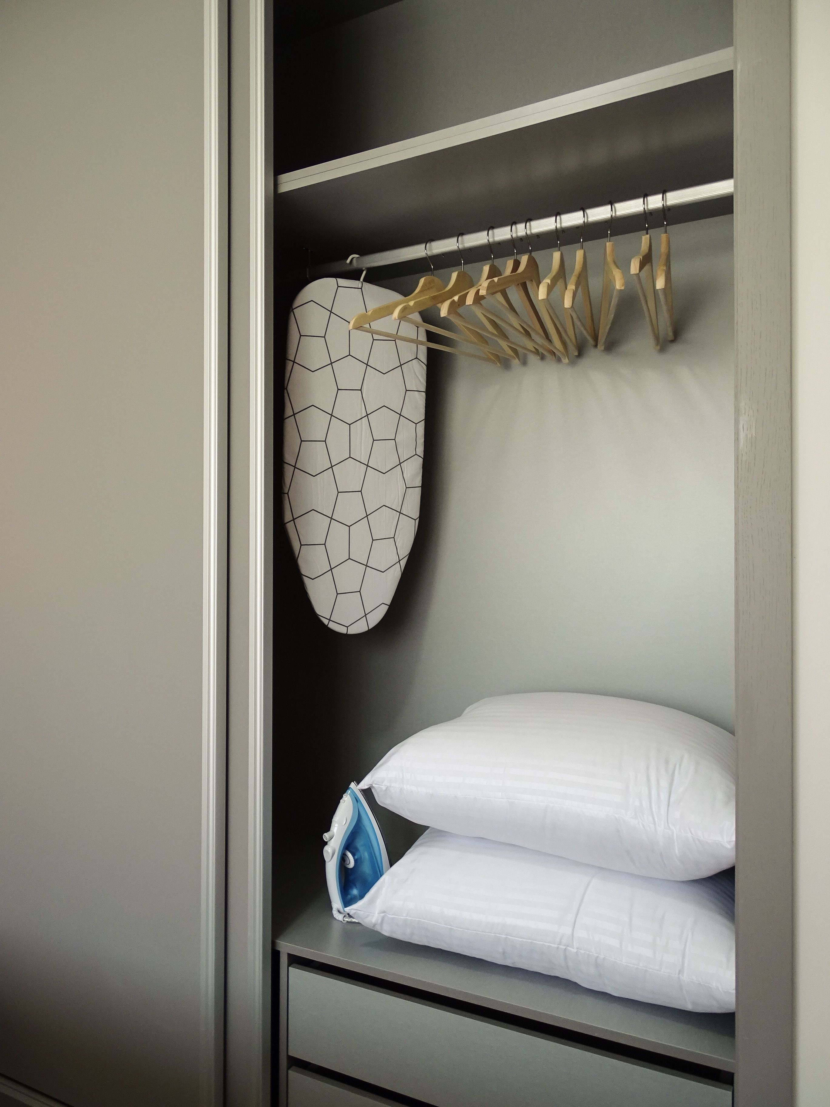 Una camera da letto con un letto, un appendiabiti e un mobile contenitore.