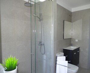 A modern bathroom with a glass-enclosed shower, a white sink, and a toilet. - Rs porto Apartments (Porto)