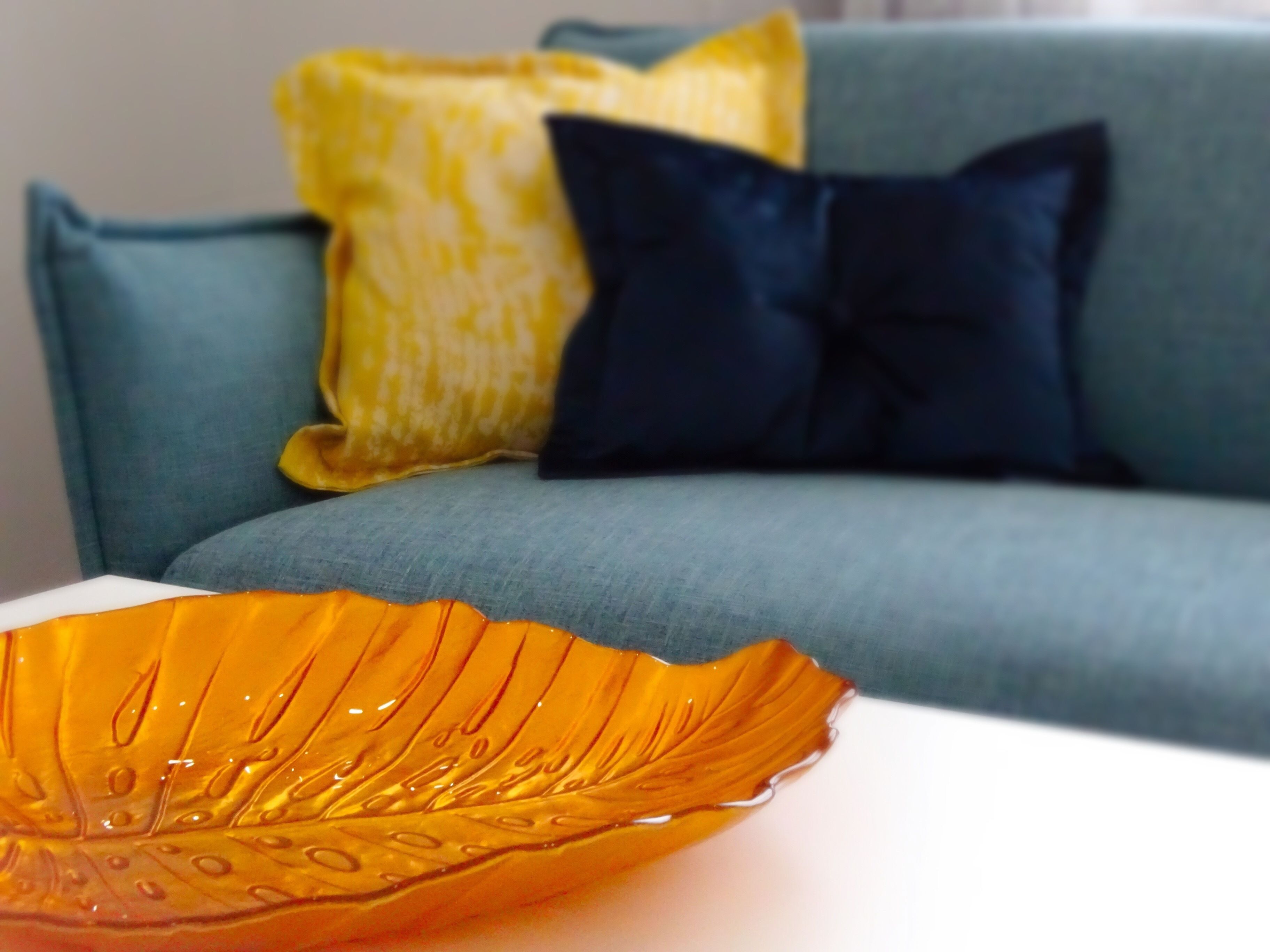 A close-up of a decorative orange glass bowl on a white surface.