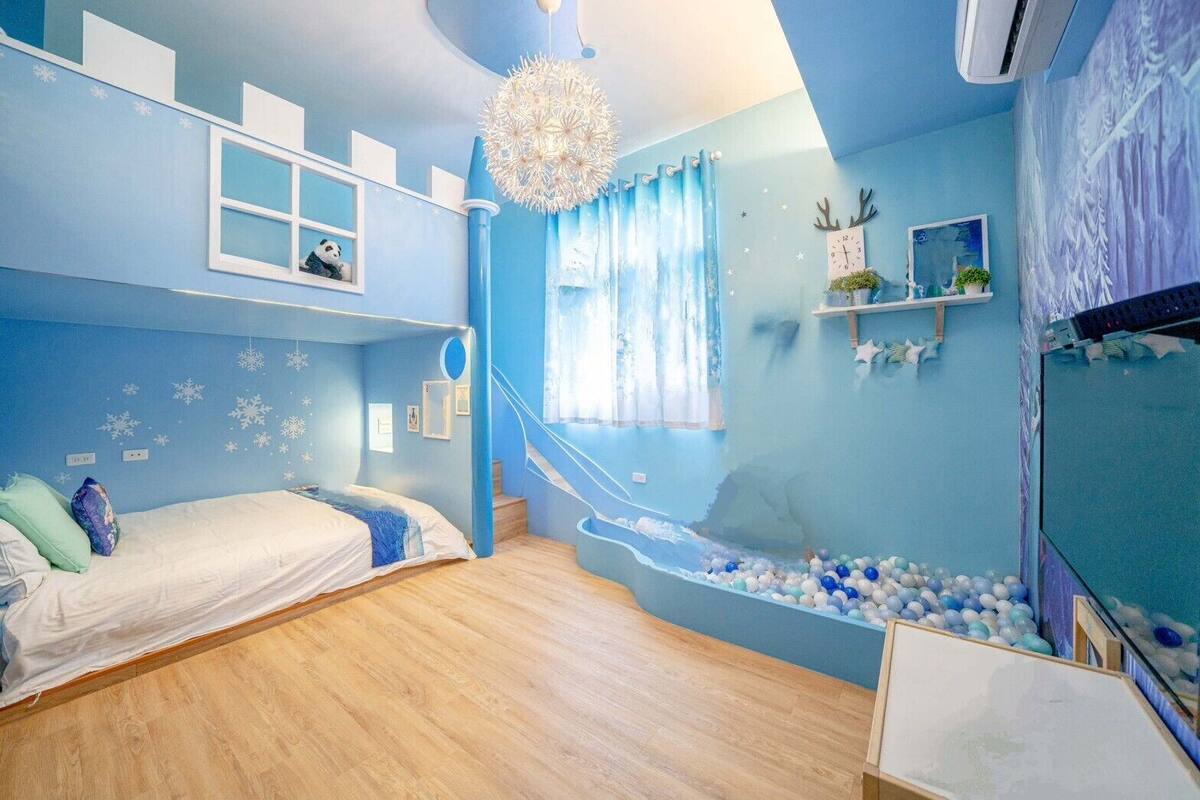 Une chambre avec un lit superposé, un toboggan et une piscine à balles.