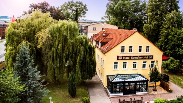 Un edificio amarillo con un letrero que dice 'Hotel Dresdner Hof'.