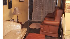 A living room with a beige sofa, a wooden coffee table, and a brown leather couch. - Dream Vacation ST Catherine Jamaica - Guest Suites for Rent in Spanish Town (Spanish Town)