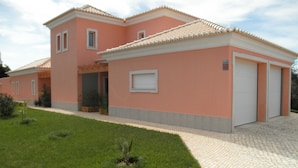 A two-story house with a tiled roof, a garage, and a paved driveway. - Villa 3 luxury Suites with Pool (loulé)
