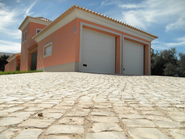 Un edificio con garaje y entrada pavimentada.
