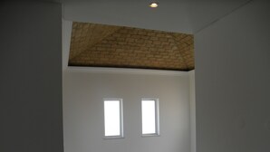 A staircase with a wooden handrail and a brick ceiling. There are two small windows on the wall. - Villa 3 luxury Suites with Pool (loulé)