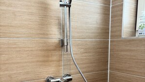 Een douche met een handdouche en een handbedienbare kraan.