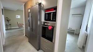 A modern kitchen with stainless steel appliances, a built-in oven, and a microwave.