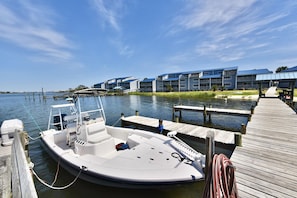 Um barco atracado no cais, com um edifício ao fundo.