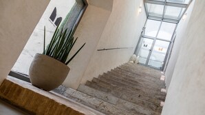 Eine Treppe mit Steinstufen, die zu einer Glastür führt.