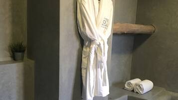 Bathroom features a toilet, bathrobe, and a small potted plant.