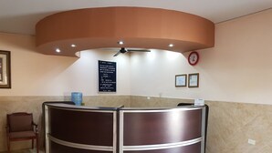 Uma receção com um relógio e certificados emoldurados na parede.