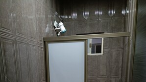 Casa de banho com sanita, lavatório e lixeira.