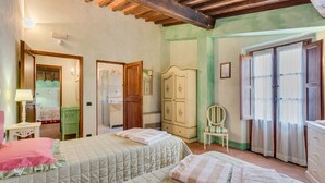 A bedroom with two beds, a wardrobe, a chair, and a window with curtains. - L'Aia, two bedrooms apartment in the Chianti area with A/C and swimming pool (Tavarnelle Val di Pesa)
