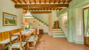 A dining area with wooden furniture, a staircase, and a green wall. - L'Aia, two bedrooms apartment in the Chianti area with A/C and swimming pool (Tavarnelle Val di Pesa)