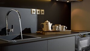 Una cocina moderna con un diseño elegante, que incluye un lavaplatos de acero inoxidable, un horno empotrado y un microondas.
