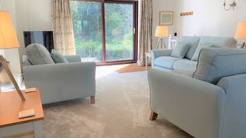 A living room with two sofas, a TV, and a lamp.