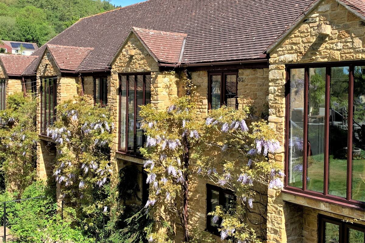 A stone building with multiple windows and a tiled roof.