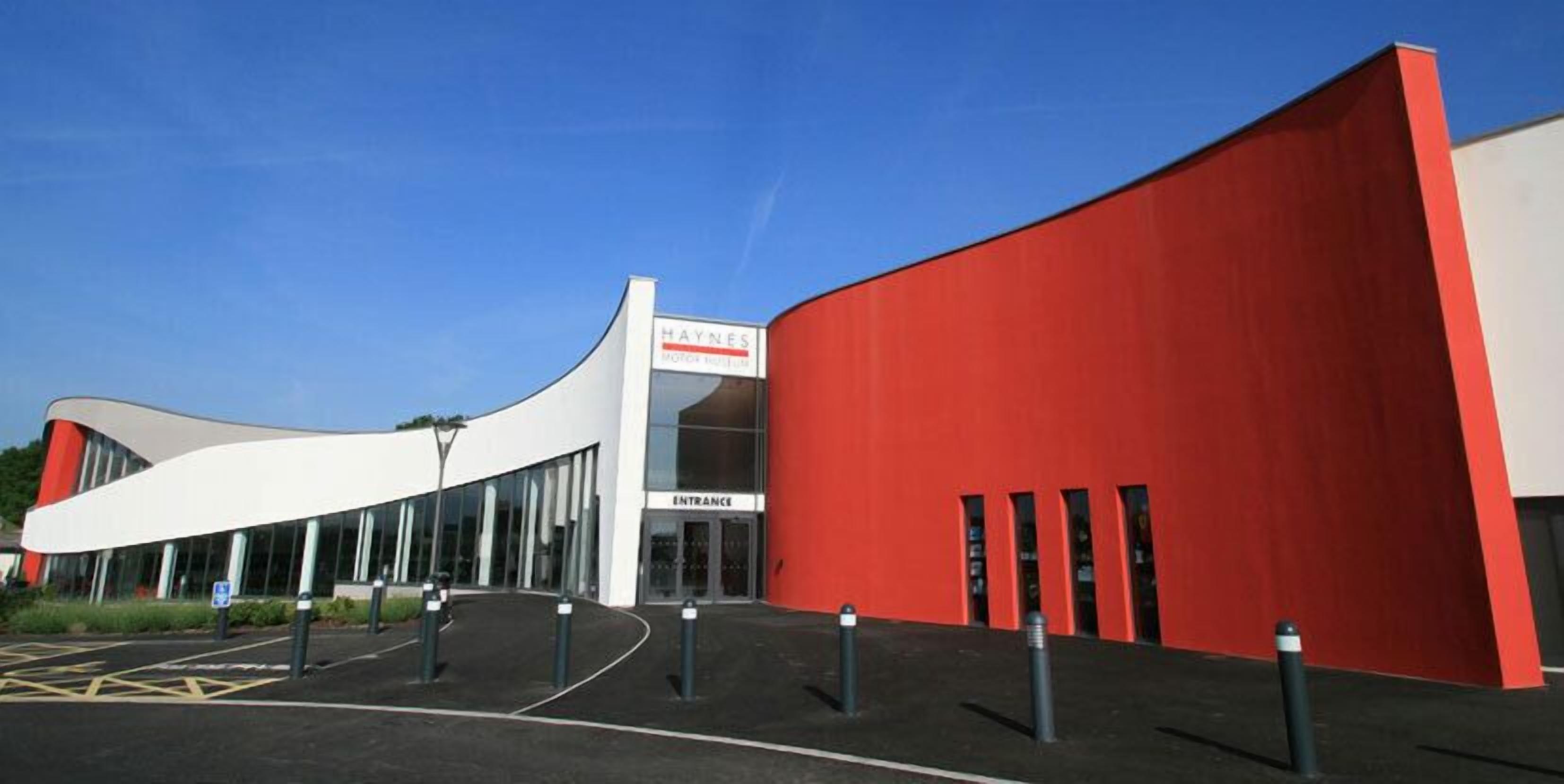 Ein modernes Gebäude mit einer gewölbten weißen Fassade und einem roten Abschnitt.