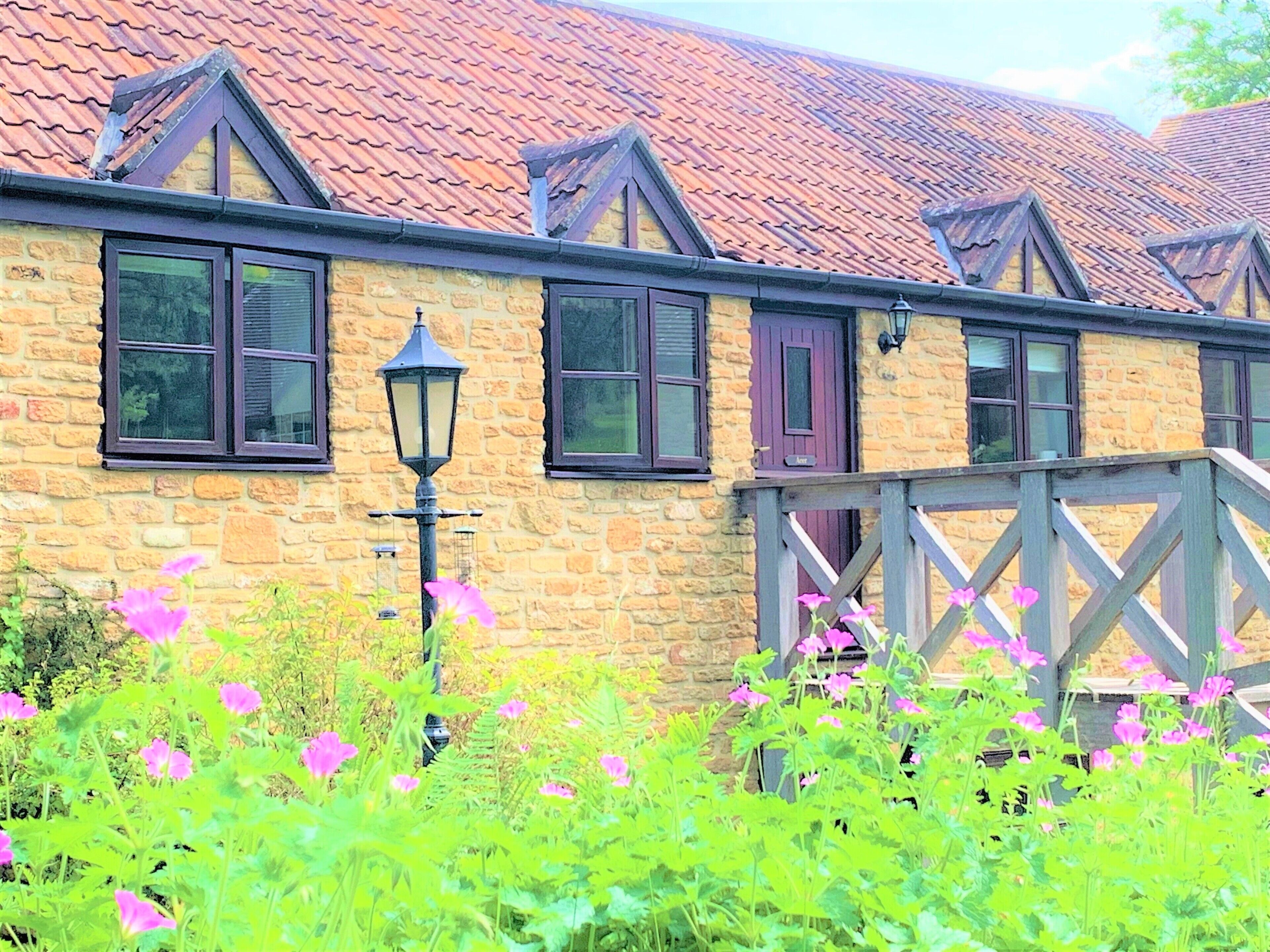 A stone building with multiple windows and a red-tiled roof.