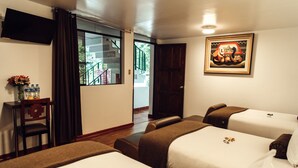A hotel room with two beds, a desk with a vase of flowers, and a painting on the wall. - Hotel Retama Machupicchu (Machu Picchu)