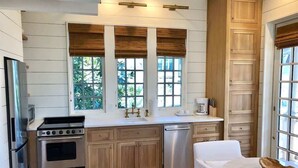 A modern kitchen with wooden cabinets, stainless steel appliances, and a white countertop.
