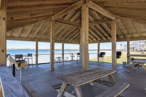 A wooden pavilion with picnic tables and chairs overlooking a body of water. - Your Sound Side Sanctuary Awaits in Palms 1-206 (Gulf Breeze)