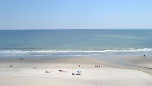 En bred sandstrand med fri utsikt över havet.