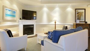 A living room with a fireplace, a television, and a ceiling fan. - Waterside Resort (Roper)