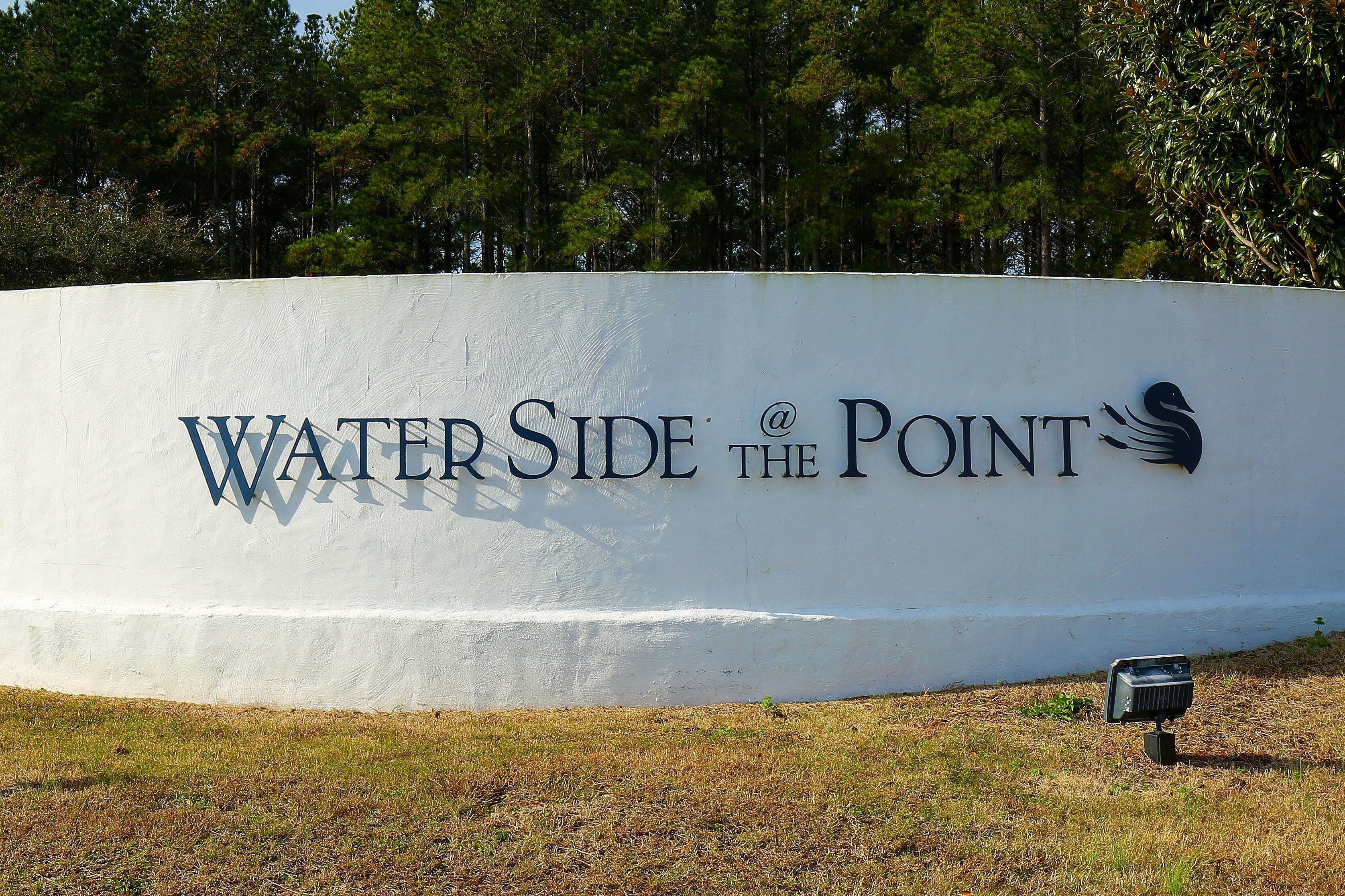 A large white wall with the text "Water Side at the Point" and a logo.