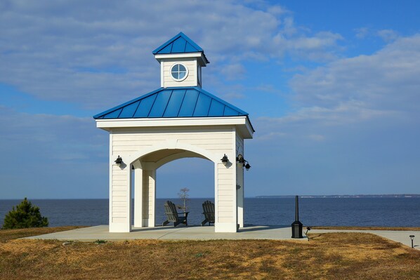 A gazebo with a blue roof and a clock tower, overlooking a body of water. - Waterside Resort (Roper)