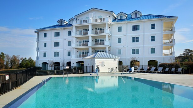 A large, multi-story hotel with a swimming pool in front. - Waterside Resort (Roper)