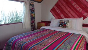 Une chambre avec un lit, une table de chevet et une fenêtre avec des rideaux.