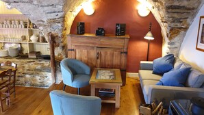 A cozy room with a wooden cabinet, two armchairs, a sofa, and a table.