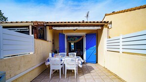 A patio with a table and chairs, a pool, and a blue door. - La Marina - Charming Holiday Home in Residence with Swimming Pool (Saint-Cyprien)