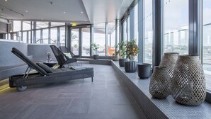 A modern lounge area with seating, large windows, and decorative planters. - Radisson blue riverside (Göteborg)