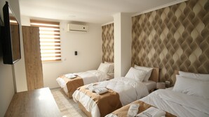 A hotel room with two beds, a TV, and a wooden desk. - Hotel Old Alisa (Skopje)