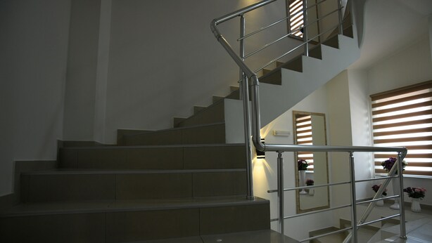 A modern staircase with metal railings and a handrail, leading to an upper floor. - Hotel Old Alisa (Skopje)